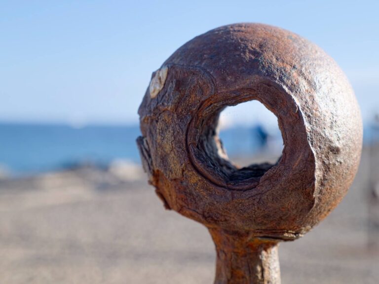 Rusty metal pole hole on beach