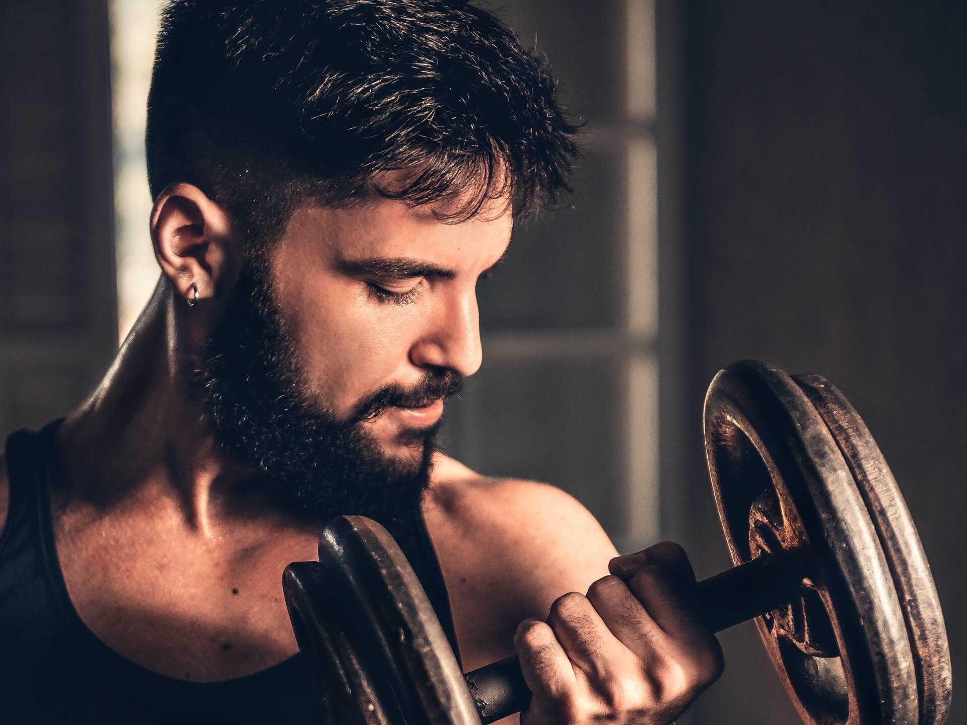 Bearded man pumping dumbbell