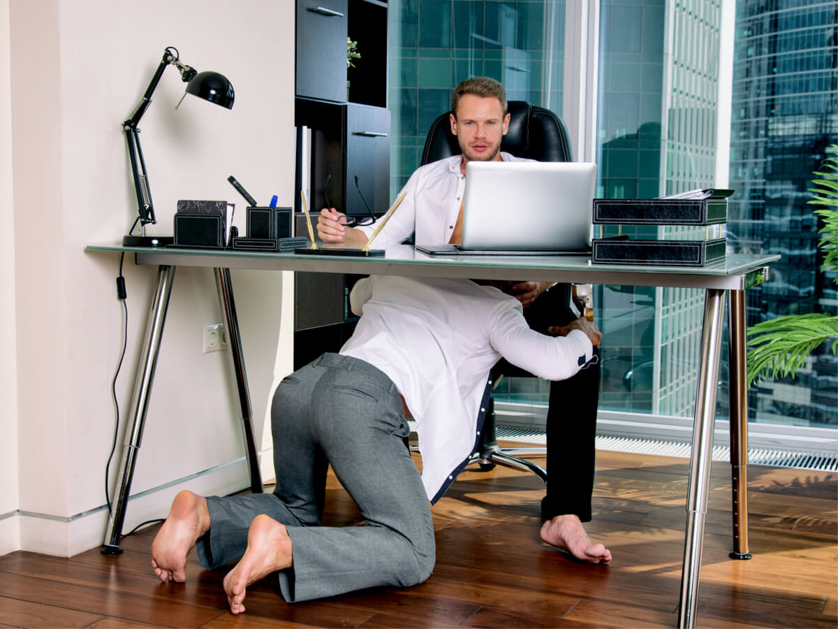 Gay businessmen in office under desk