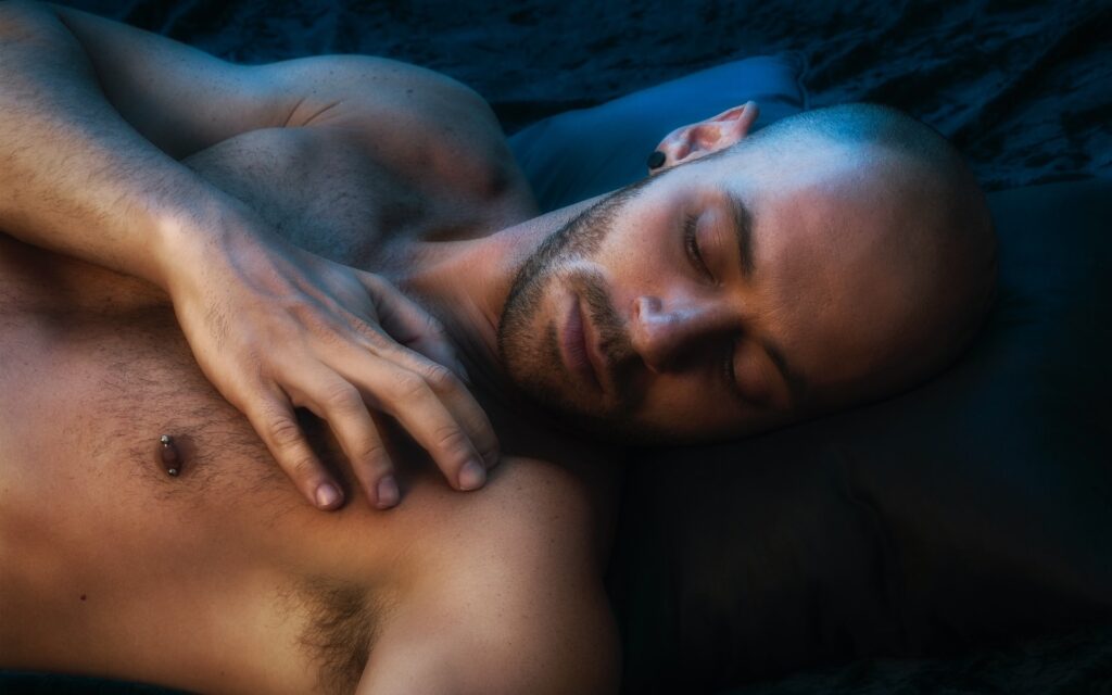 Shirtless Bearded Man Lying Face Up Shirtless bearded man lying down with eyes closed