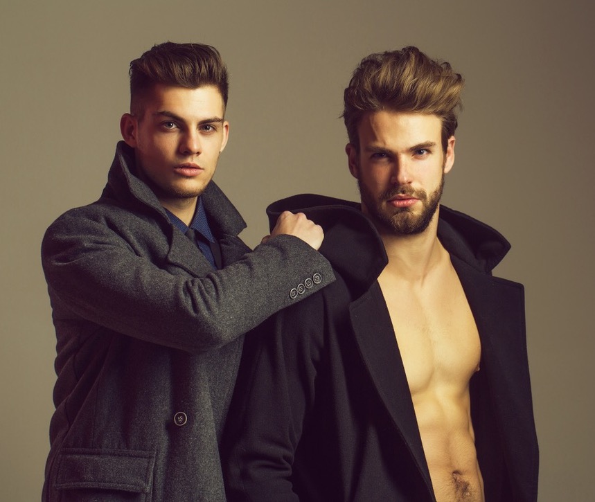 Two Men in Coats with One Shirtless Two men in coats with one shirtless